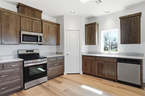 a kitchen with stainless steel appliances granite countertop a stove microwave and sink