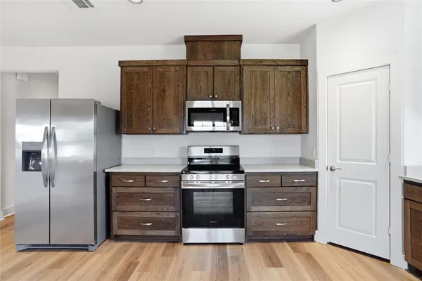 a kitchen with granite countertop wooden cabinets and stainless steel appliances