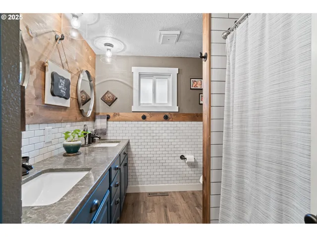 a bathroom with a granite countertop sink a mirror a vanity and shower curtain