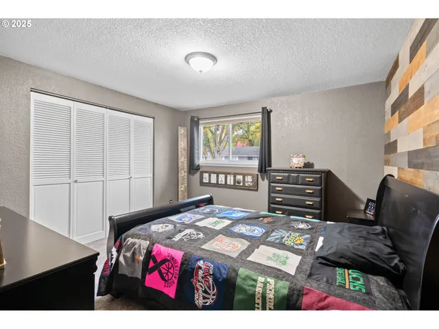 a bedroom with a bed dresser and a window