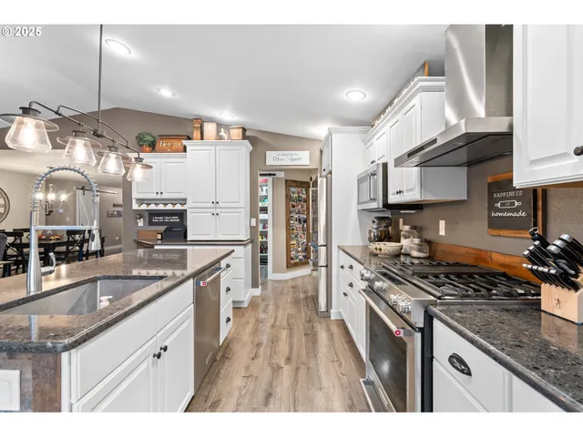 a kitchen with stainless steel appliances granite countertop a stove and a sink