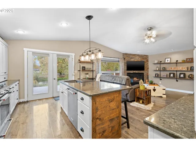 a kitchen with kitchen island granite countertop a sink counter top space and stainless steel appliances
