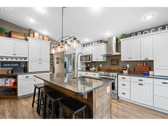 a kitchen with kitchen island a stove a table and chairs in it