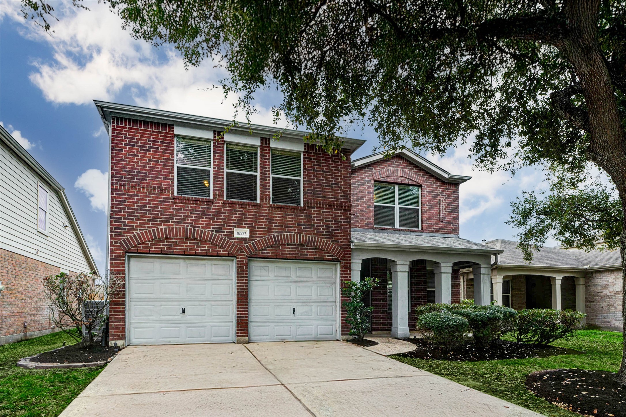 18327 Atasca Wds Trace Humble, TX 77346 - Photo 1 of 28 a front view of a house with a garden
