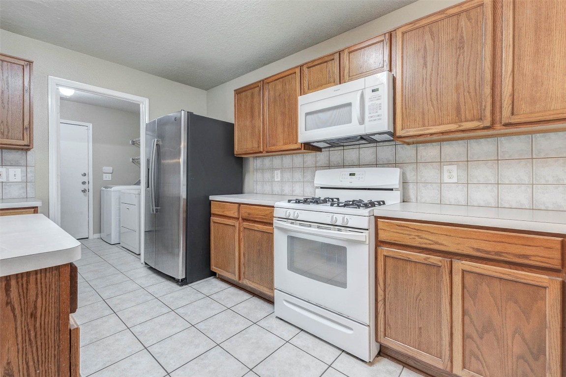 18327 Atasca Wds Trace Humble, TX 77346 - Photo 12 of 28 a kitchen with a stove sink and refrigerator