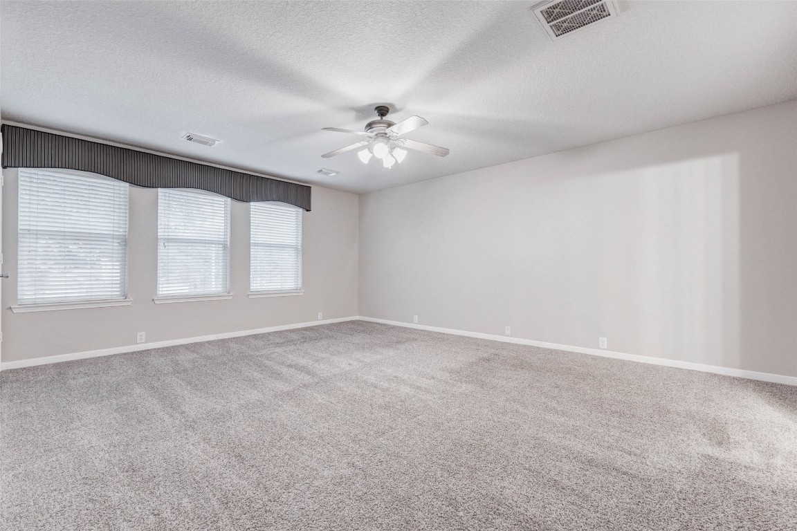 18327 Atasca Wds Trace Humble, TX 77346 - Photo 13 of 28 an empty room with windows and ceiling fan