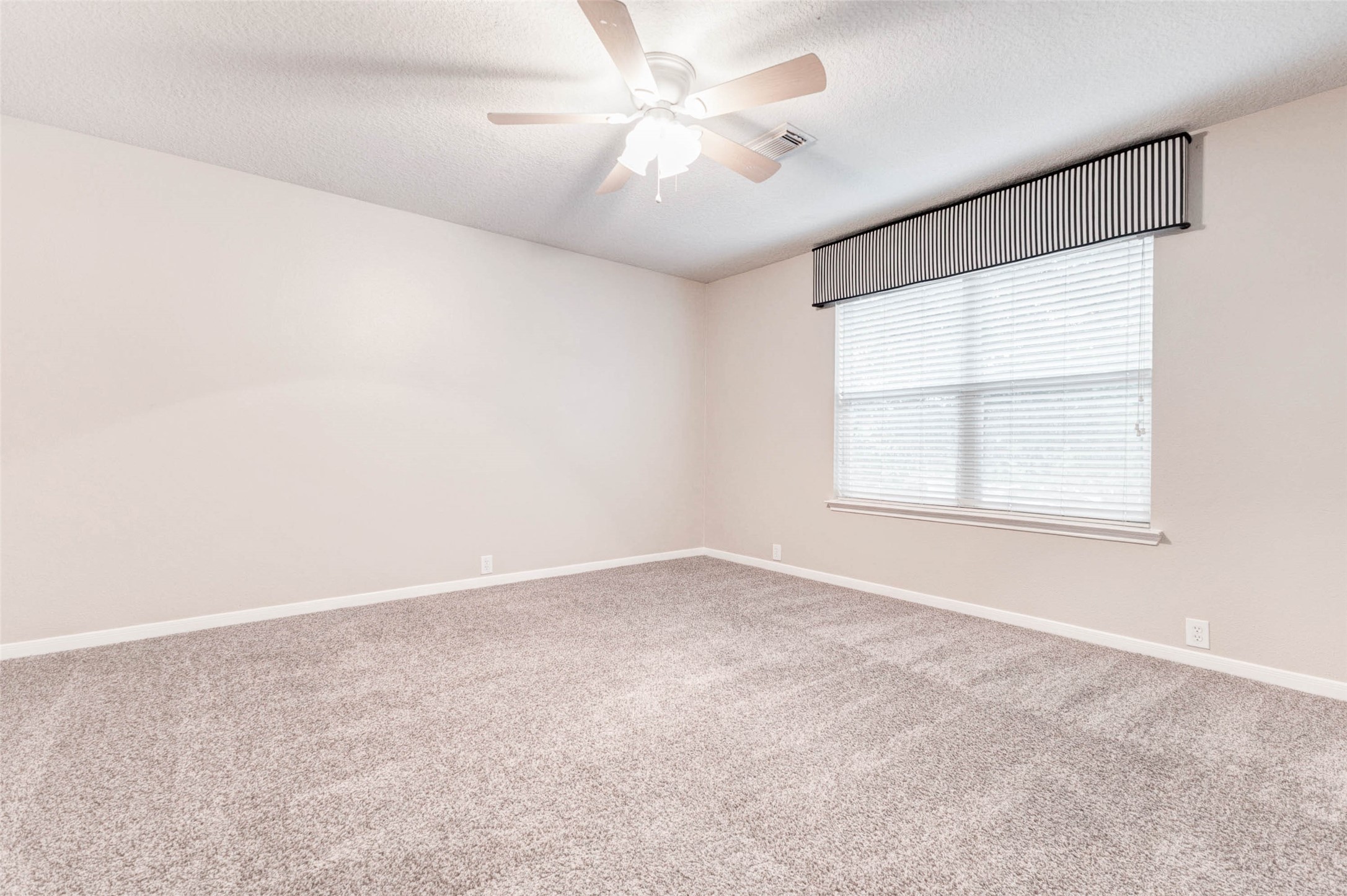 18327 Atasca Wds Trace Humble, TX 77346 - Photo 22 of 28 an empty room with windows and ceiling fan
