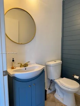 a bathroom with a toilet a sink and mirror