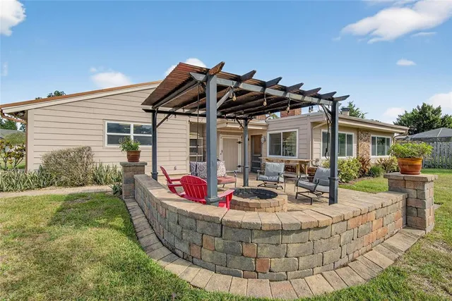 a view of a big house with a big yard and large trees