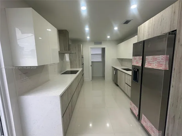a kitchen with stainless steel appliances granite countertop a refrigerator a sink and a stove
