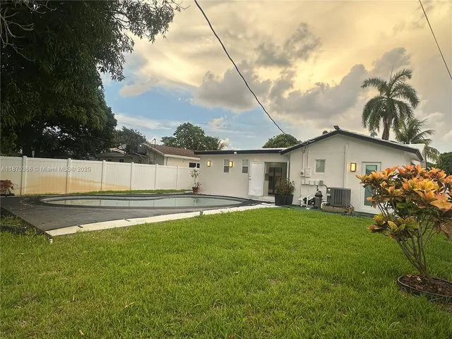 a view of a backyard with grass and a large tree