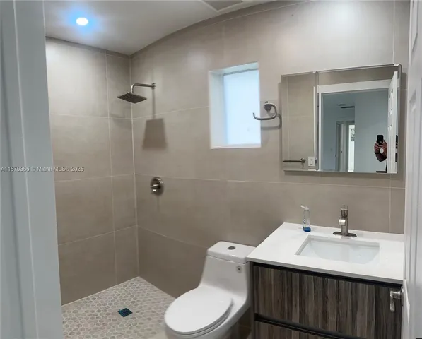 a bathroom with a sink toilet a mirror and shower