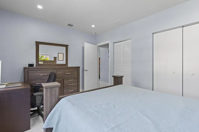 a bedroom with a bed and painting on the wall