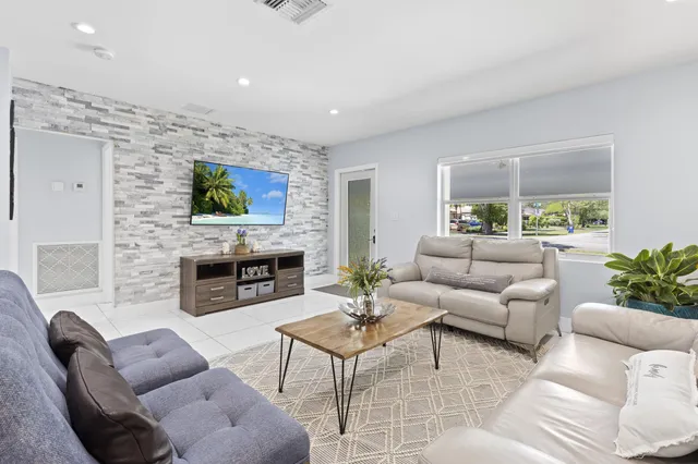 a living room with furniture a fireplace and a flat screen tv