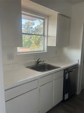 a utility room with sink a window and appliances