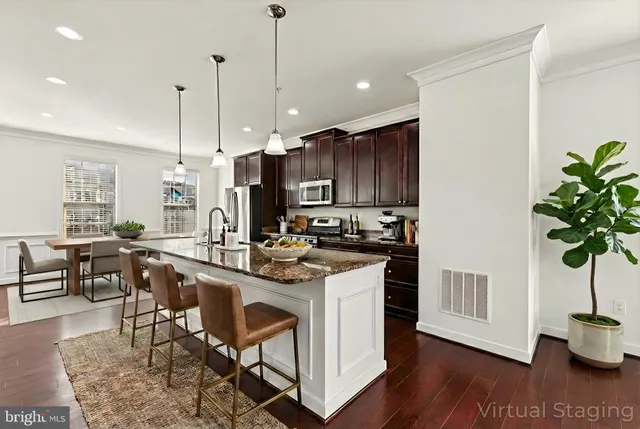 a large kitchen with stainless steel appliances granite countertop a stove a sink a refrigerator and a wooden floor