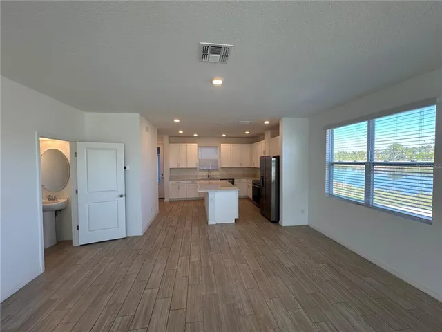a open kitchen with white cabinets and wooden floor