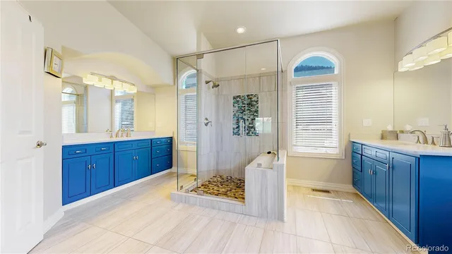 a spacious bathroom with a granite countertop sink a toilet a mirror and shower