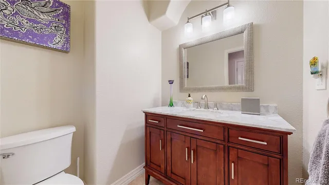 a bathroom with a granite countertop sink a toilet and a mirror