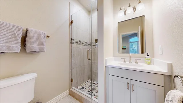 a bathroom with a sink a mirror a vanity and a shower