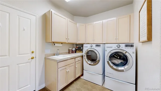 a utility room with sink dryer and washer