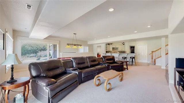 a living room with furniture a large window and gym equipment