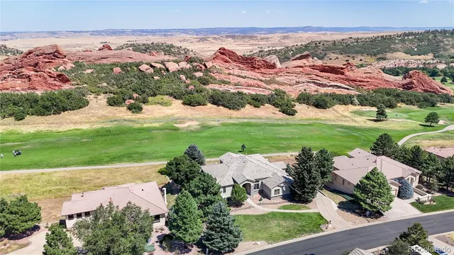 an aerial view of residential houses with outdoor space and trees