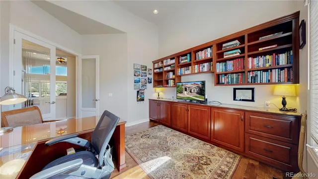a living room with stainless steel appliances kitchen island granite countertop a couch and a bookshelf in it