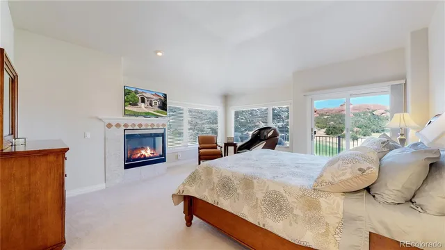 a bed sitting in a bedroom next to a fireplace with a painting on the wall