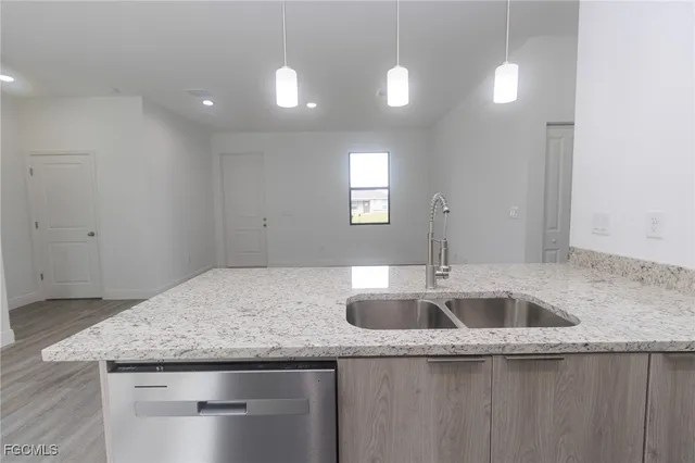 a kitchen with granite countertop a sink and dishwasher