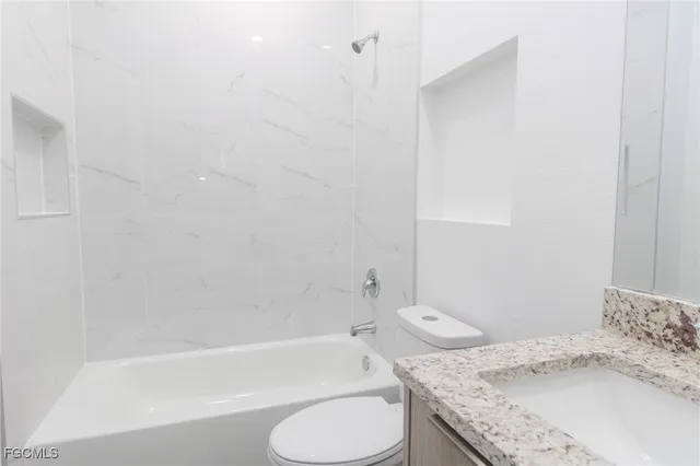 a bathroom with a granite countertop sink toilet and bathtub