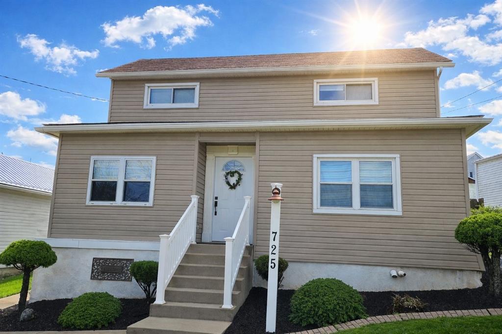 725 Longfellow Street Vandergrift, PA 15690 - Photo 1 of 14 a front view of a house with wooden stairs and a large tree