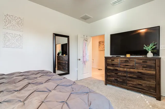 a bedroom with a bed and a flat screen tv