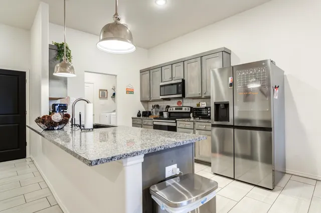a kitchen with stainless steel appliances granite countertop a sink refrigerator and microwave