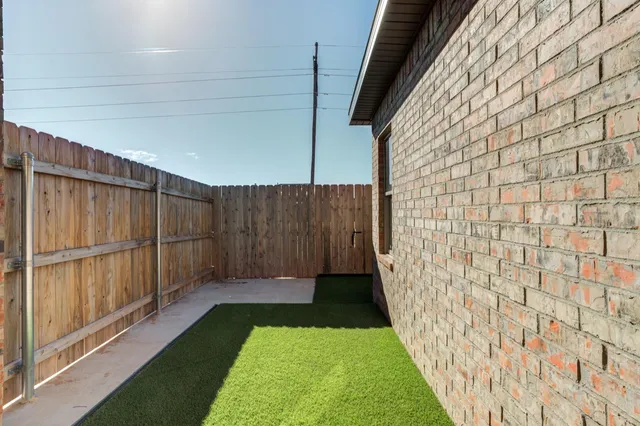 a view of a backyard with wooden fence