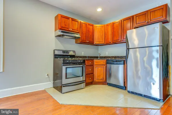 a kitchen with stainless steel appliances granite countertop a stove a refrigerator and a sink