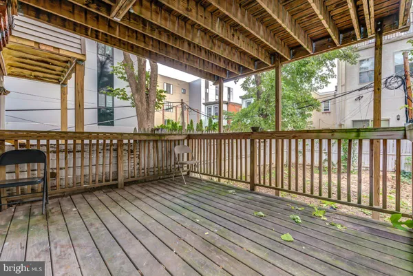 a view of a brick house with plants and wooden fence