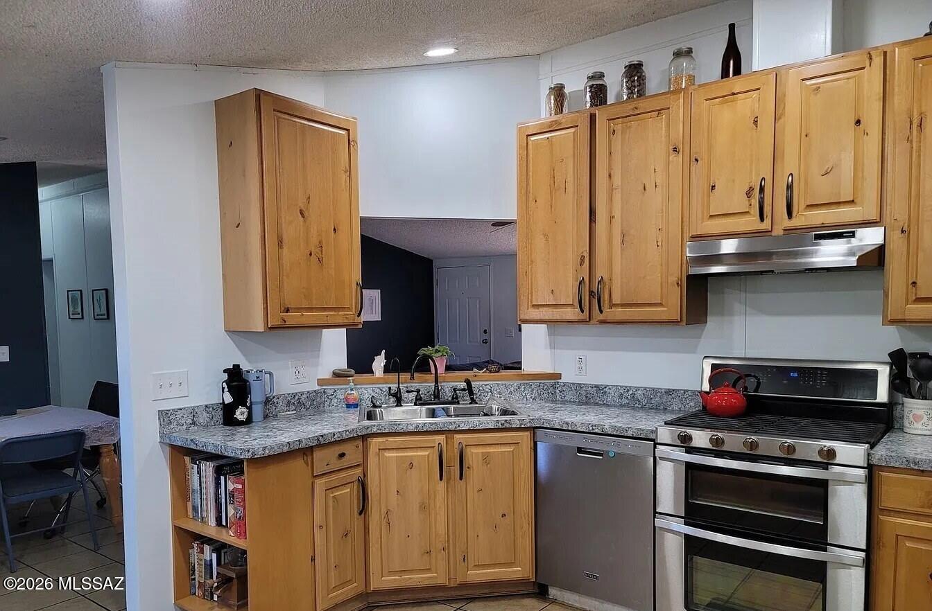 11323 North Anway Road Marana, AZ 85653 - Photo 2 of 3 a kitchen with stainless steel appliances granite countertop a sink stove and cabinets