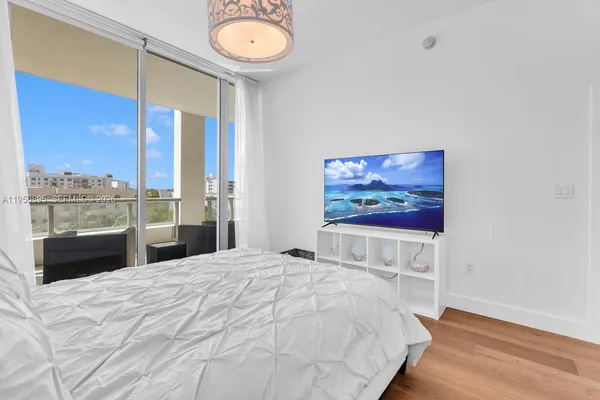a bedroom with a large bed and a chandelier