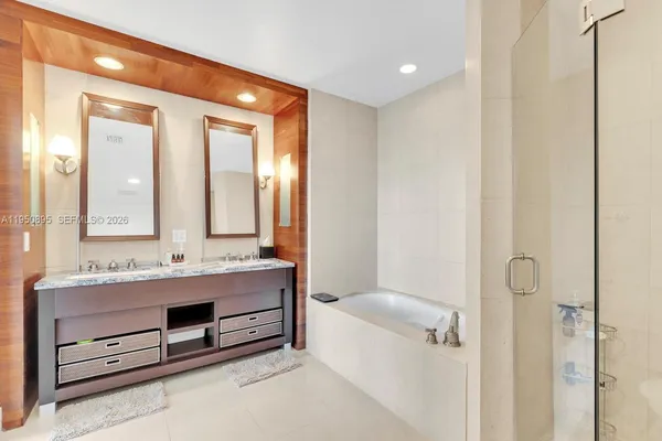a bathroom with 2 sink tub and a mirror