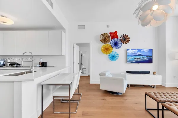 a living room with furniture and a dining table with wooden floor