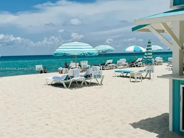 a view of a patio with a table and chairs under an umbrella