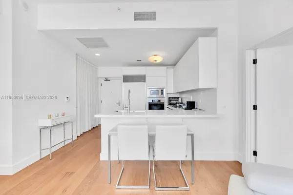 a kitchen with stainless steel appliances a stove a sink a refrigerator and white cabinets