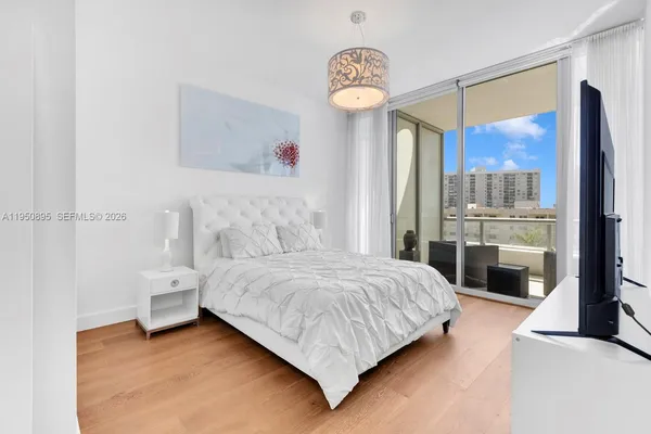 a bedroom with a large bed and a chandelier