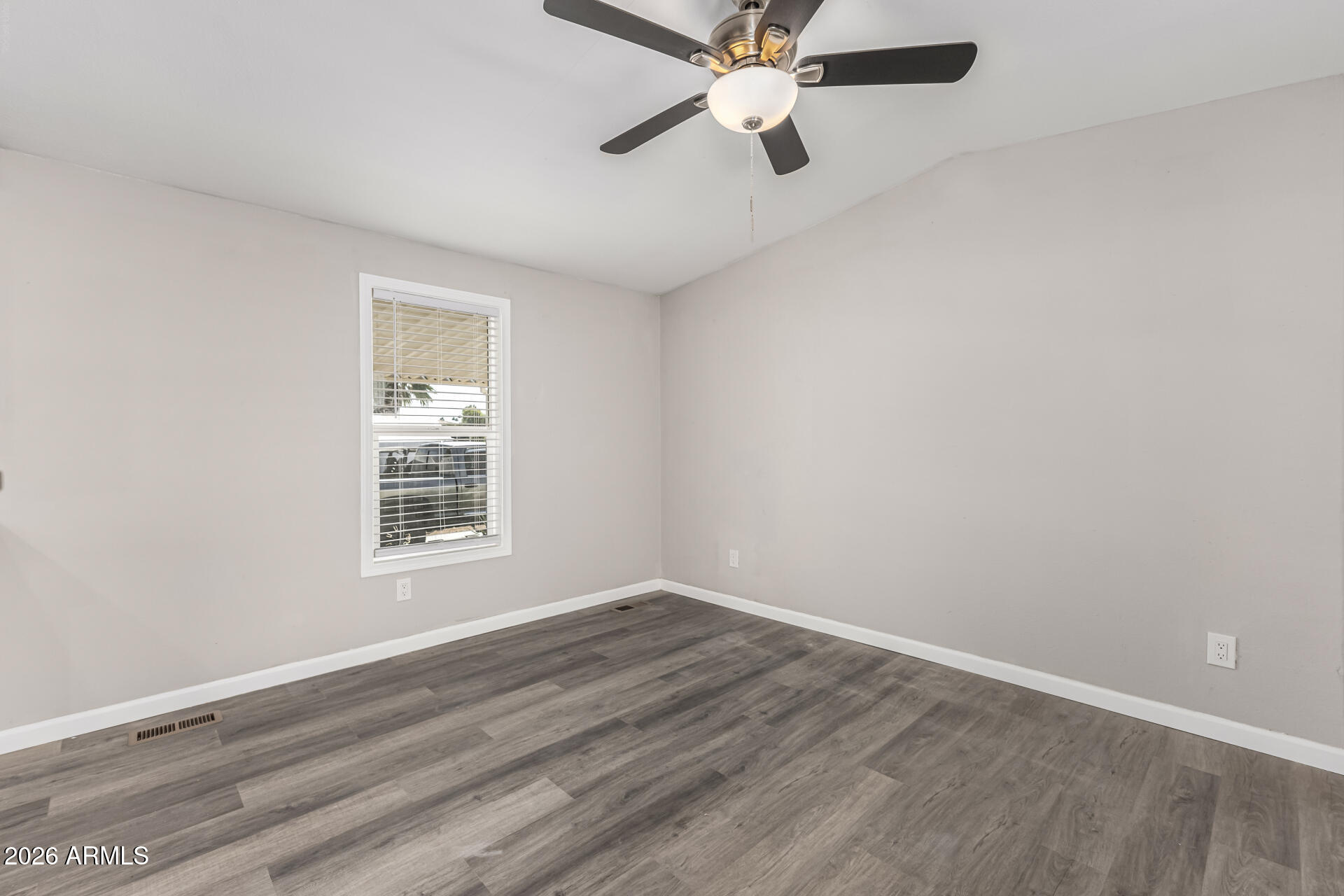 625 West McKellips Road, Unit 330 Mesa, AZ 85201 - Photo 8 of 46 an empty room with wooden floor fan and windows