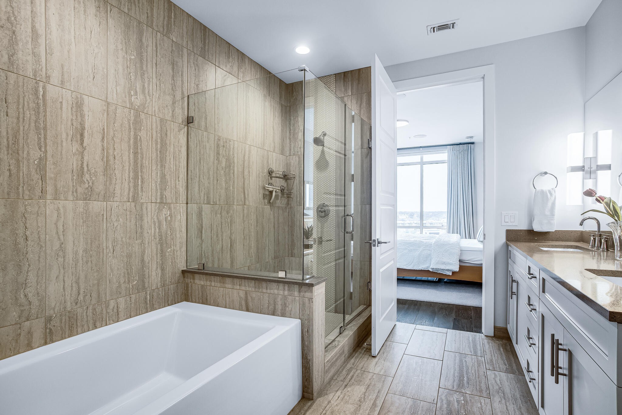 20 Rutledge Street, Unit 407 Nashville, TN 37210 - Photo 16 of 39 a bathroom with a tub a sink and a large mirror