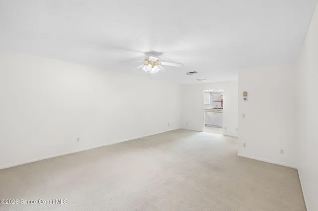 an empty room with chandelier fan