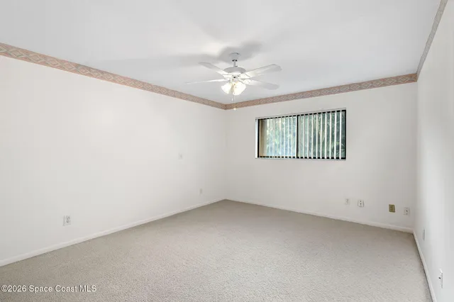 an empty room with a window and a ceiling fan