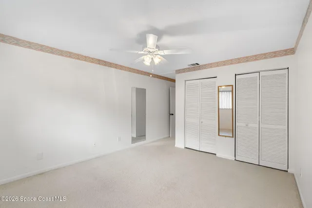 an empty room with a ceiling fan and a window
