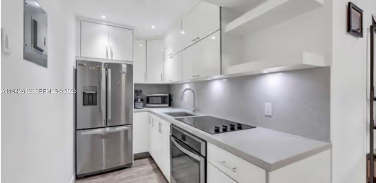 4841 Northwest 7th Street, Unit 3034 Miami, FL 33126 - Photo 12 of 35 a kitchen with a stove a refrigerator and a sink